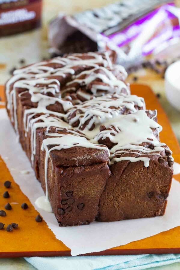 Loaf of chocolate pull apart bread drizzled with icing.