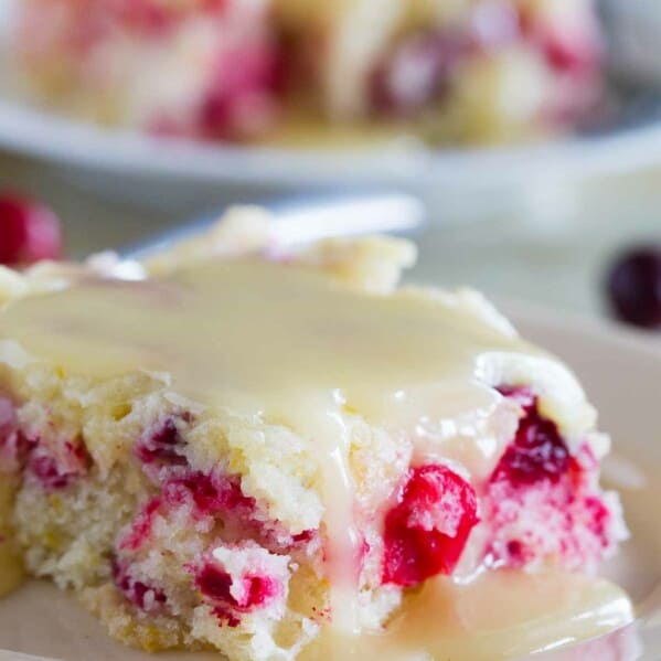 Slice of cranberry cake with warm butter sauce over the top