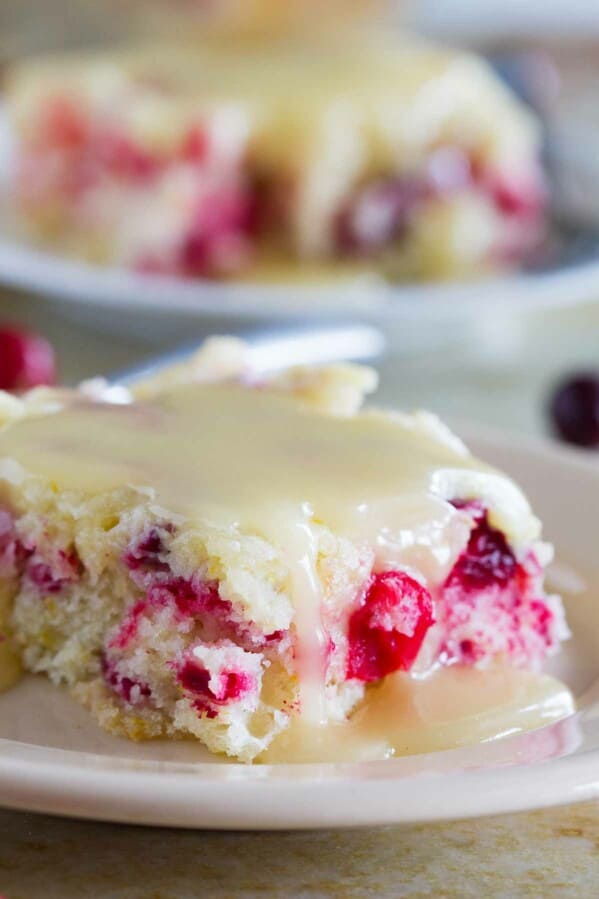 Slice of cranberry cake with warm butter sauce over the top