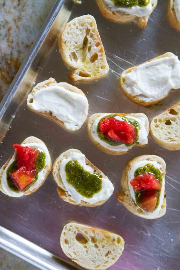 A true crowd pleasing appetizer, this Feta, Pesto and Tomato Bruschetta is a tasty appetizer that can be served year round. Perfect as a starter or as a holiday party appetizer.