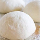 balls of pizza dough with flour