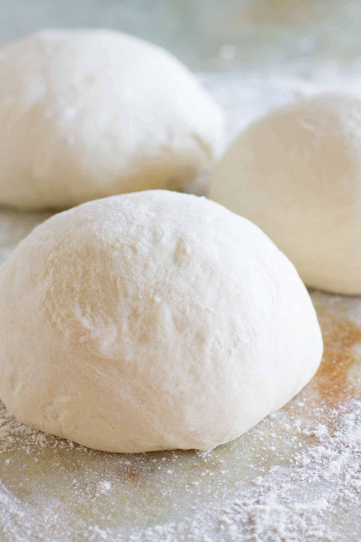 balls of pizza dough with flour.