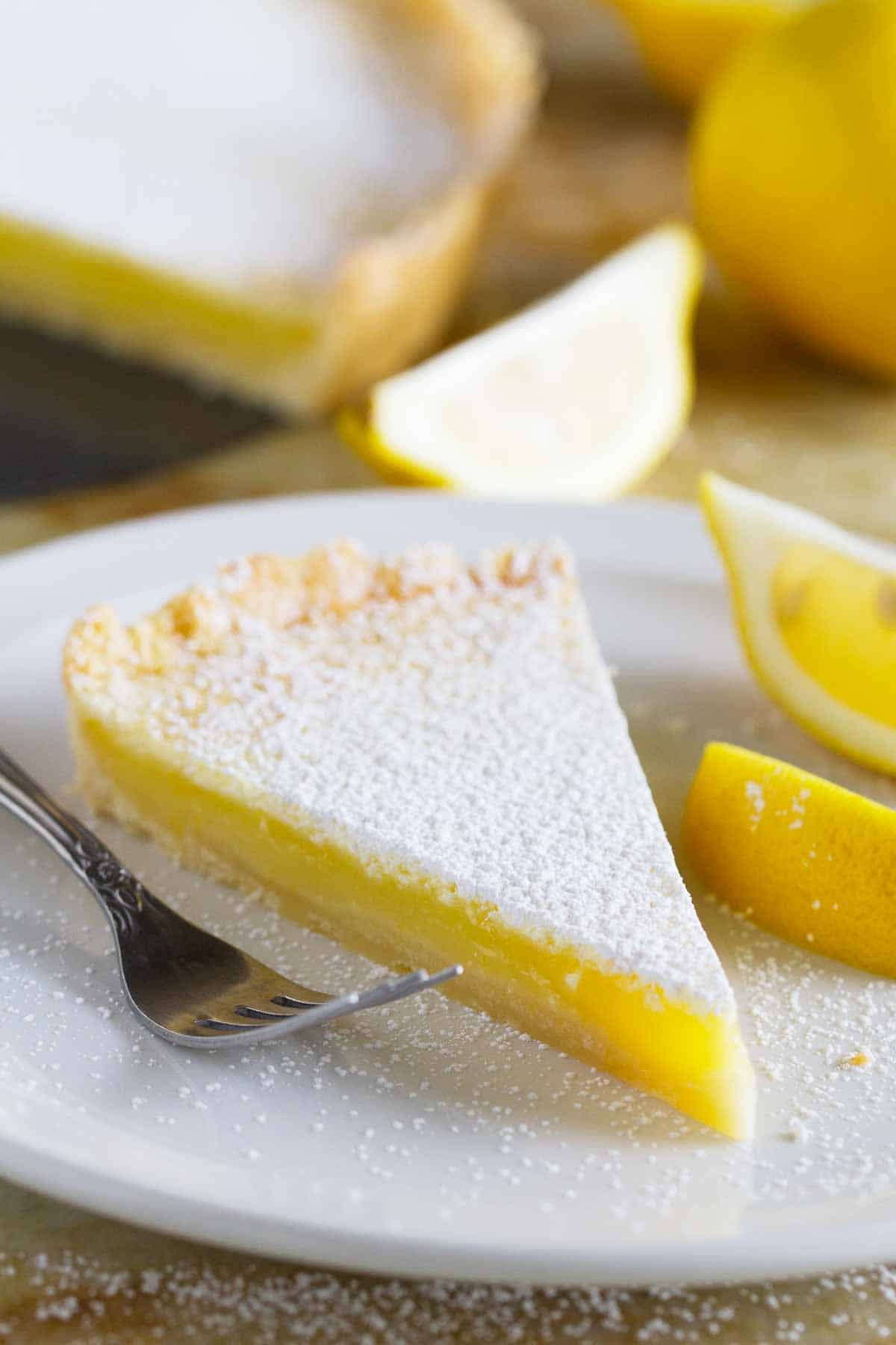 Slice of shortbread lemon tart on a plate.