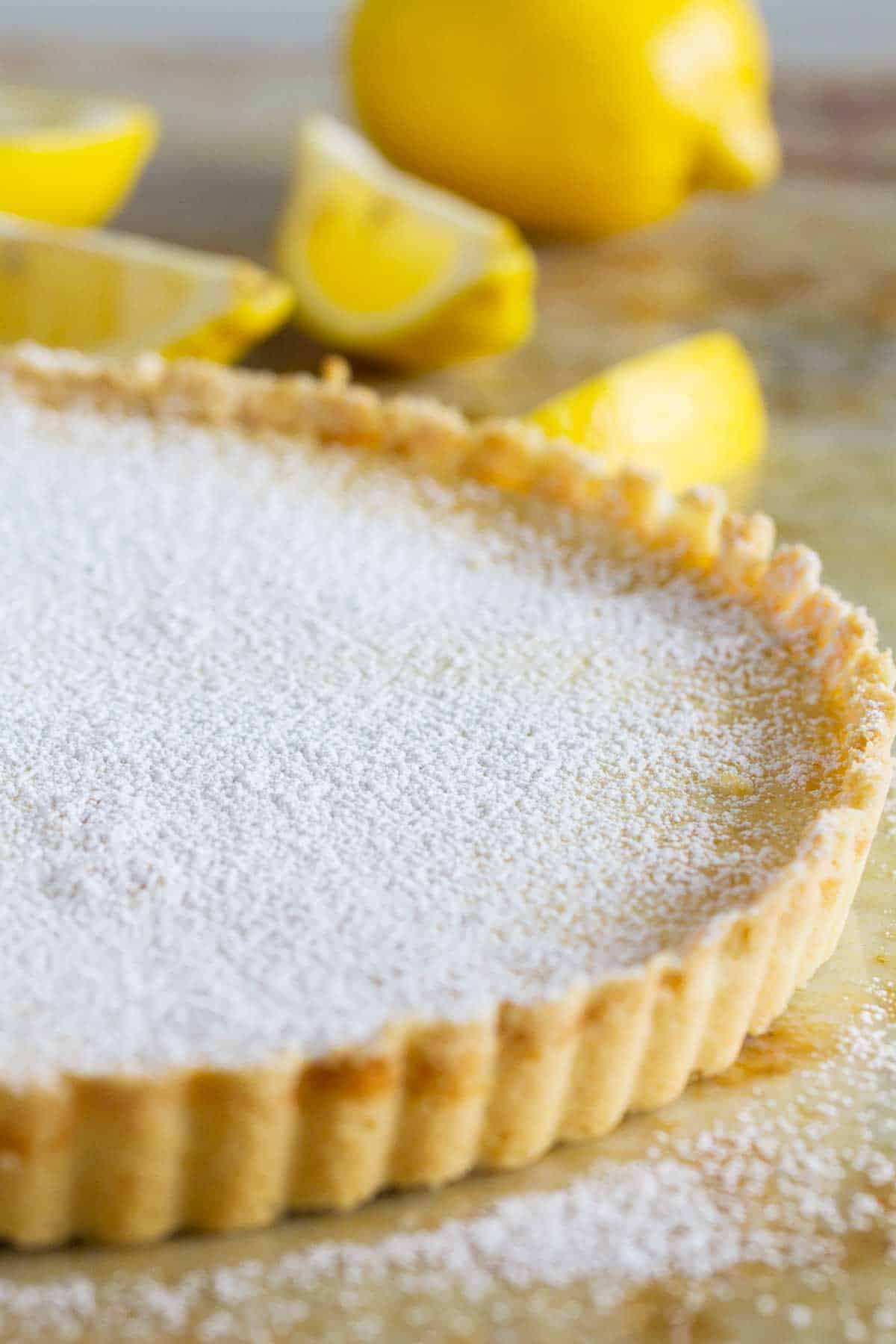 Full shortbread lemon tart sprinkled with powdered sugar.