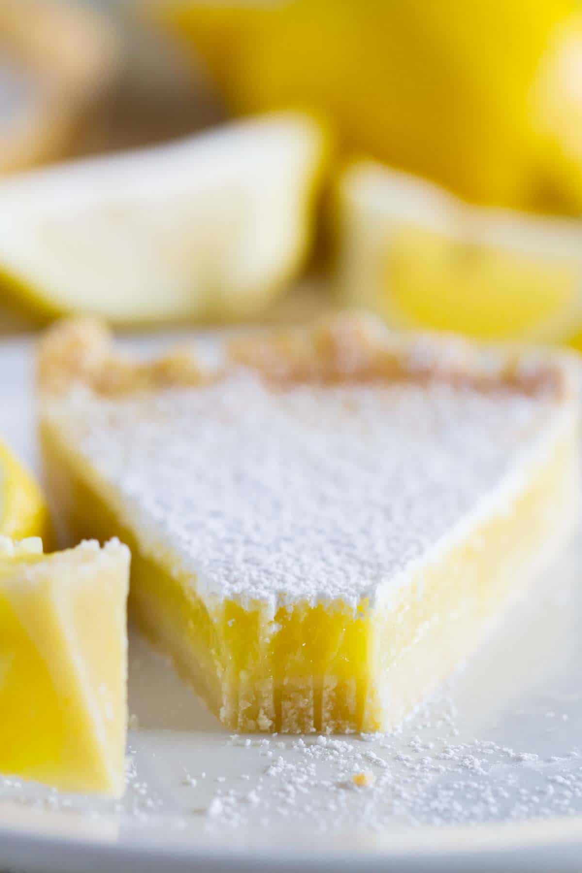 Slice of shortbread lemon tart with a bite taken from it.