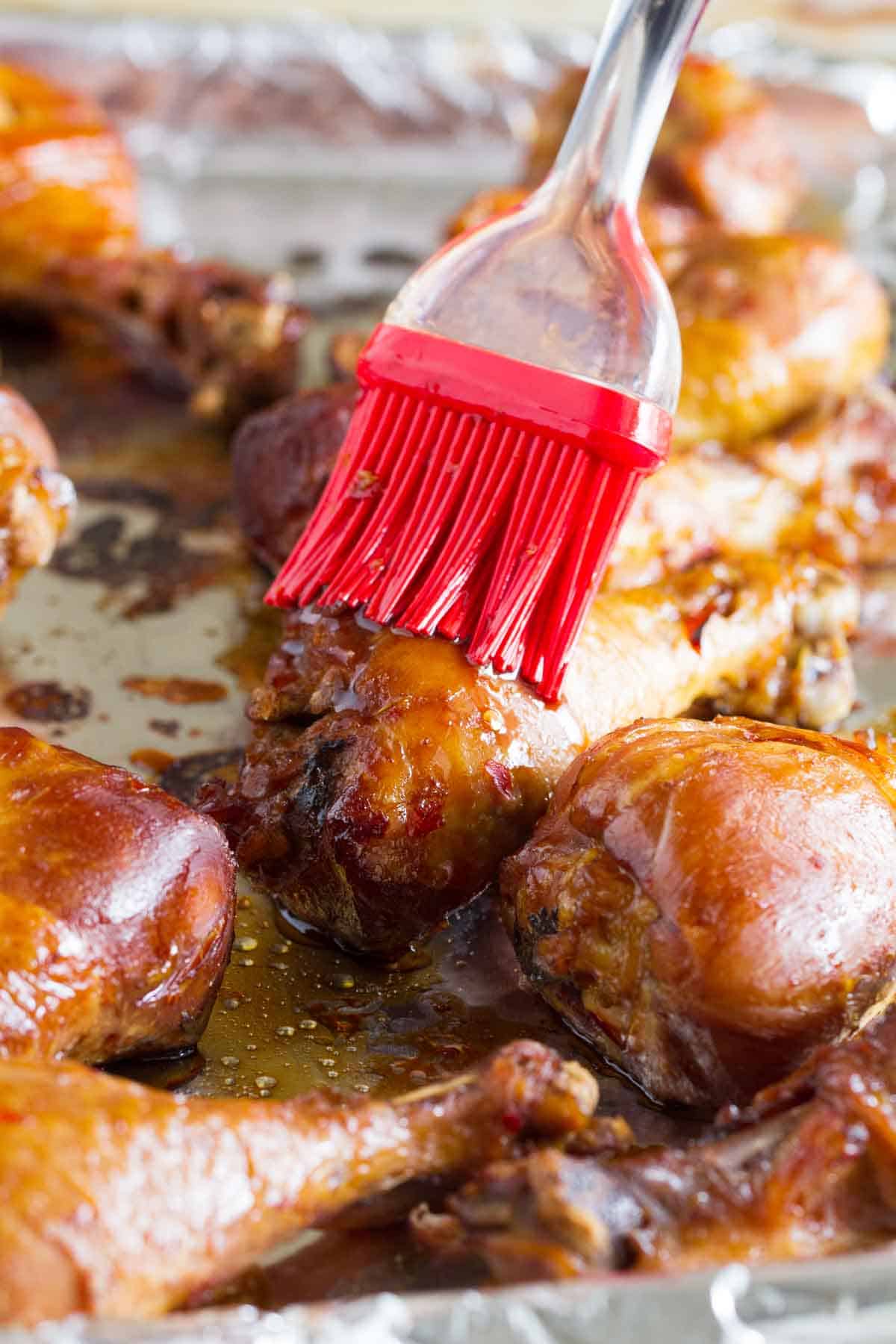 brushing sauce on sweet chili chicken drumsticks