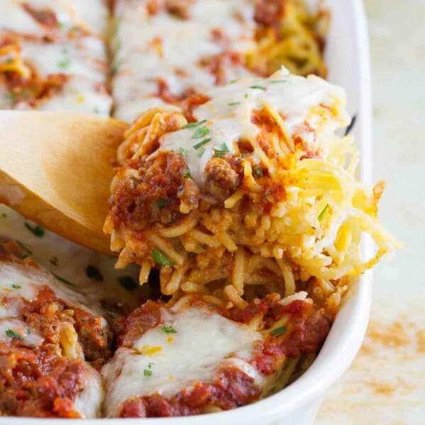 Dishing spaghetti lasagna out of a baking dish.