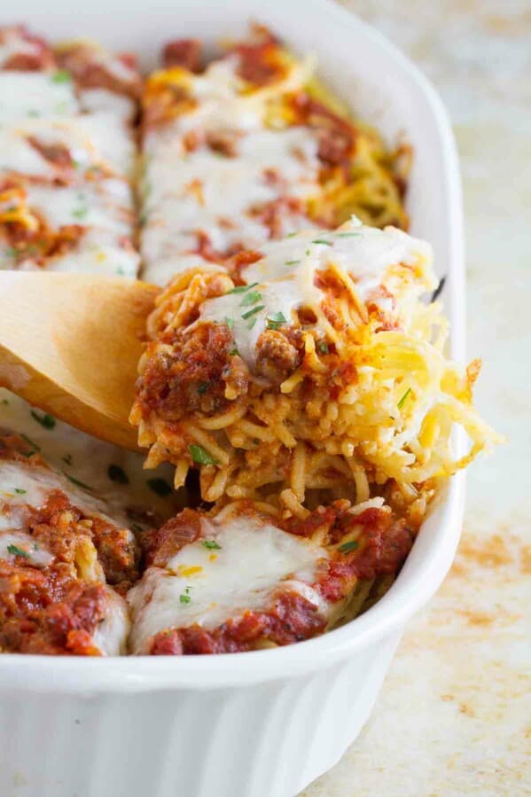 Dishing spaghetti lasagna out of a baking dish.