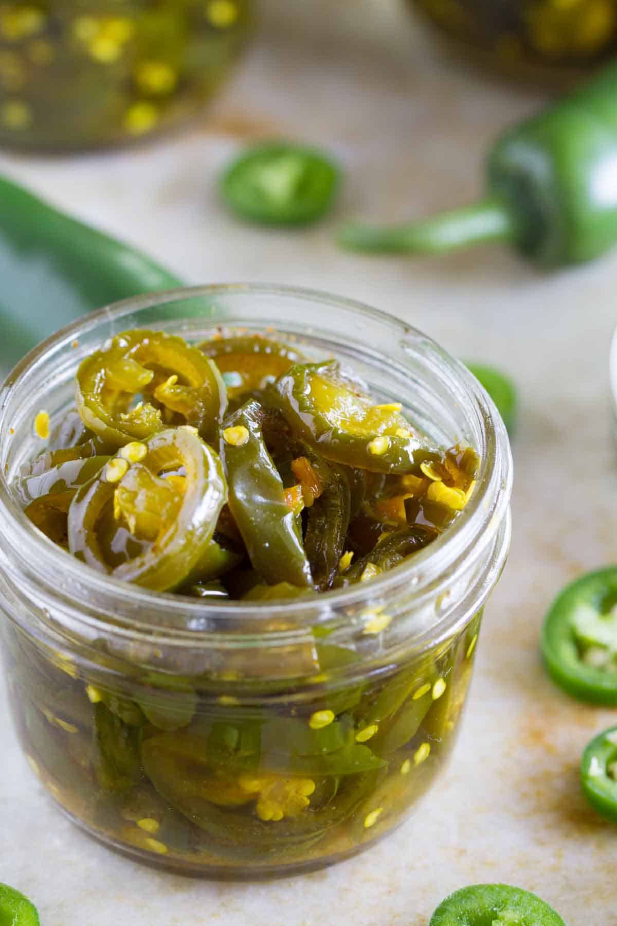 Small jar filled with candied jalapeños.