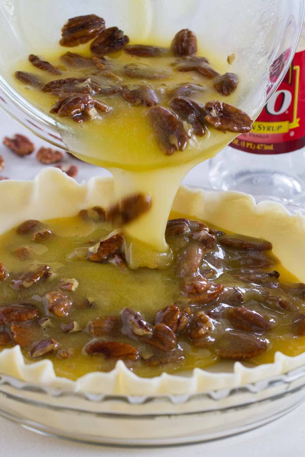 Pouring filling into a pecan pie.