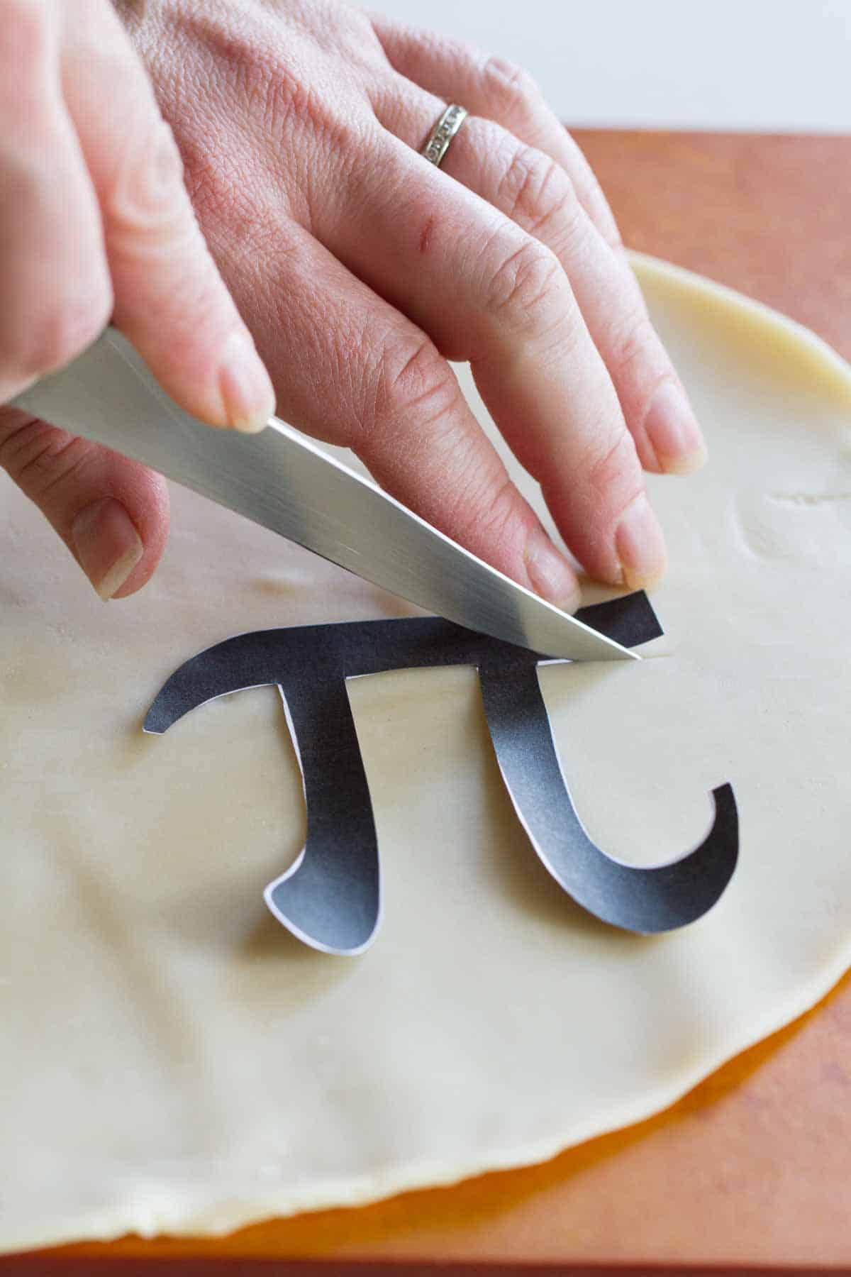 Cutting out pi sign to put on a pie.