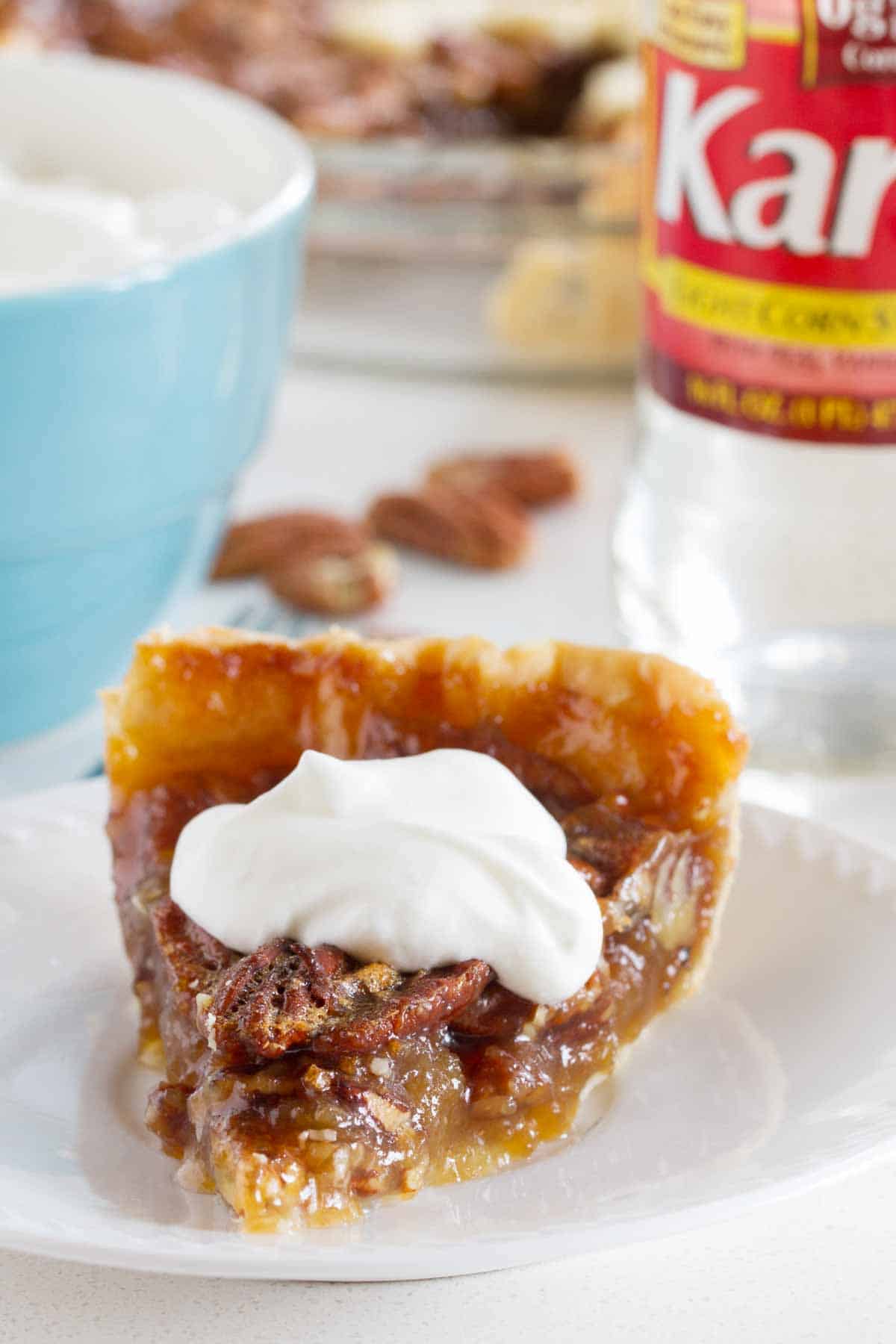 Slice of Pecan Pie topped with whipped cream.
