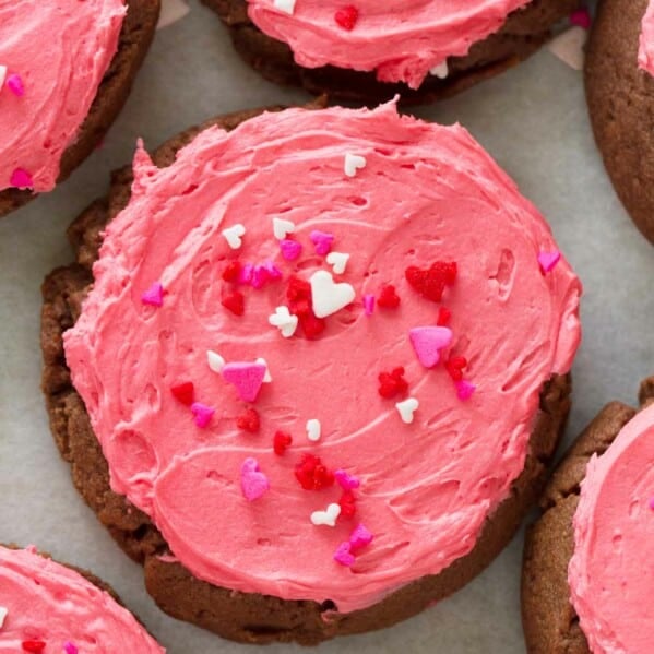 overhead view of chocolate sugar cookie with pink frosting and sprinkles