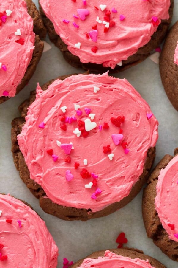 overhead view of chocolate sugar cookie with pink frosting and sprinkles