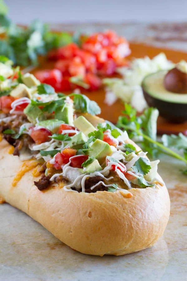 Taco Tuesday looks a little different with this Taco French Bread Pizza taking center stage! All of your favorite taco flavors are nested in a loaf of French bread for a dinner the whole family loves.
