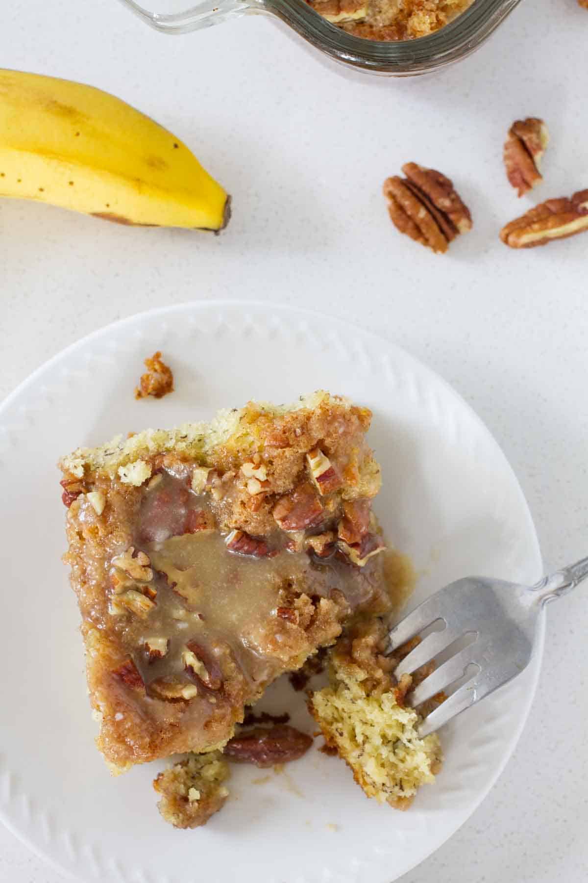 slice of banana coffee cake with a fork taking a bite