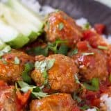 Slow cooker Mexican meatballs served over rice.