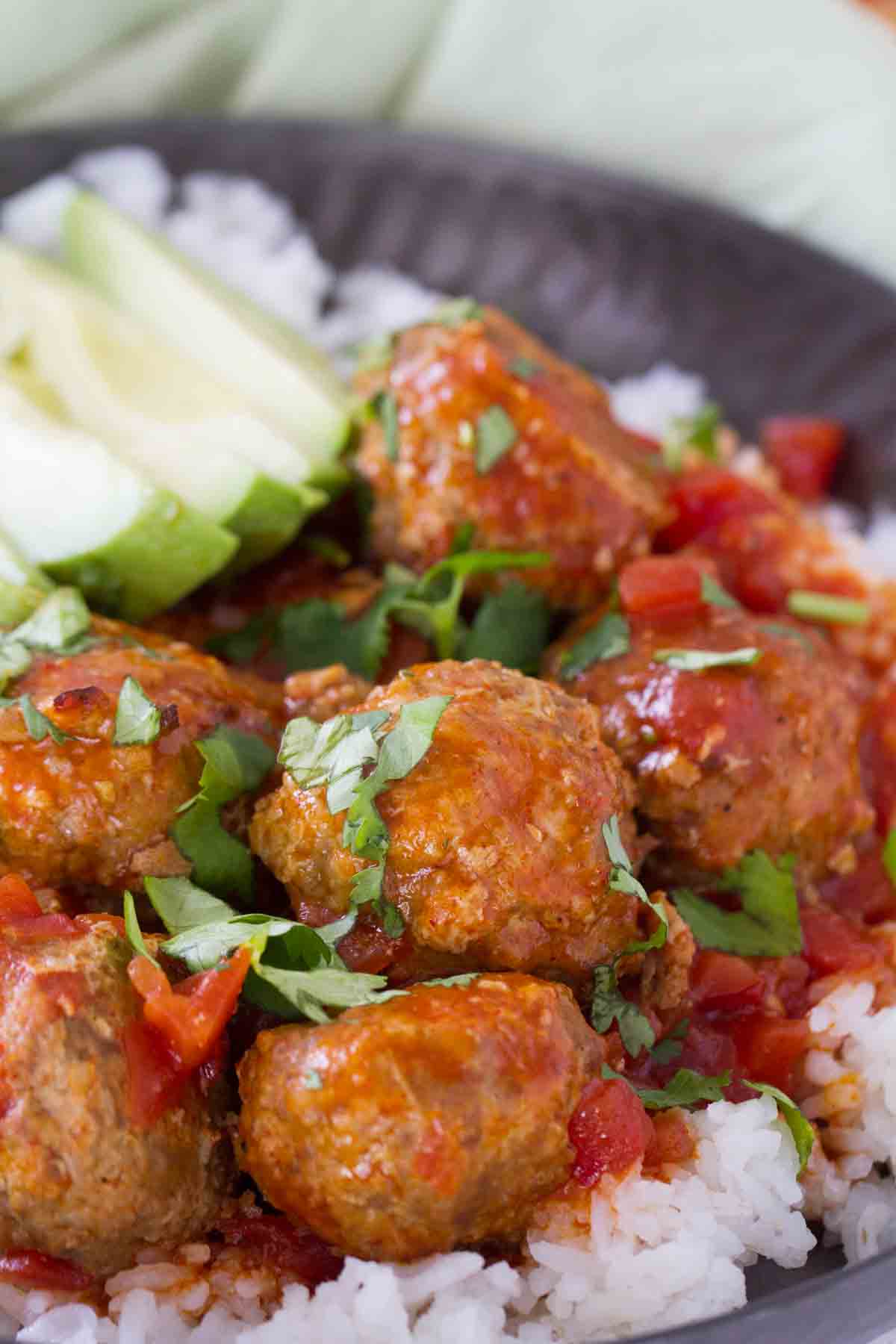 Slow cooker Mexican meatballs served over rice.