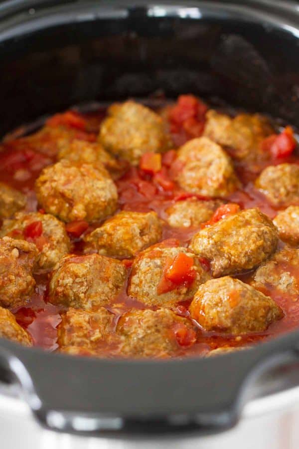 Taco spiced meatballs are slow cooked in an easy enchilada sauce. Serve these Tex-Mex Slow Cooker Meatballs over rice or tortilla chips or turn them into a Tex-Mex style hoagie sandwich!