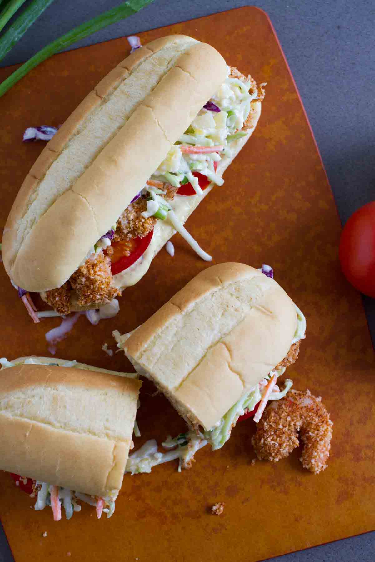 Two shrimp po boy sandwiches with one cut in half.