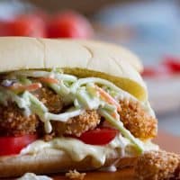 Shrimp Po Boy sandwich with creamy sauce, tomatoes, baked shrimp, and pineapple slaw.