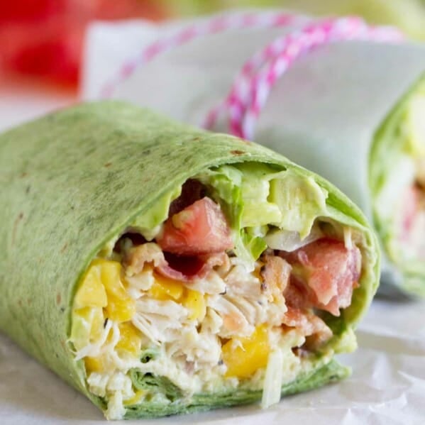 California Club Chicken Wrap with shredded chicken, avocado, mango, bacon, lettuce, and tomatoes.