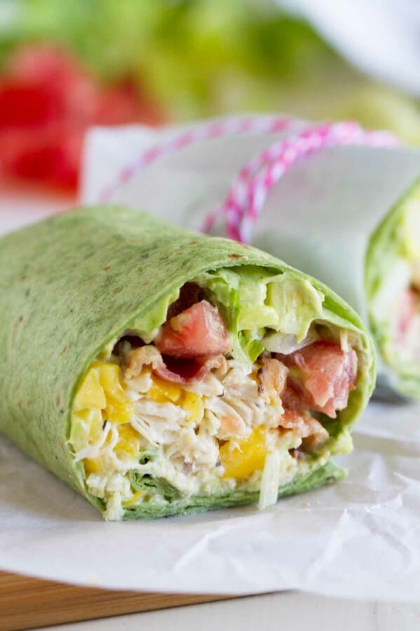 California Club Chicken Wrap with shredded chicken, avocado, mango, bacon, lettuce, and tomatoes.