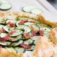 Full zucchini tart with ricotta and bacon on a cutting board