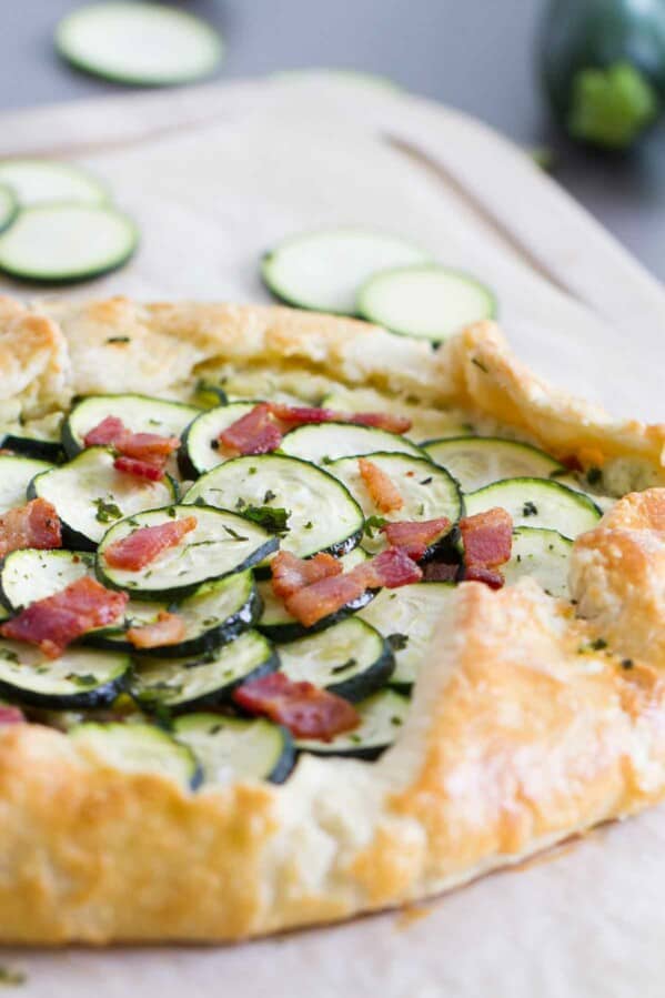 Full zucchini tart with ricotta and bacon on a cutting board