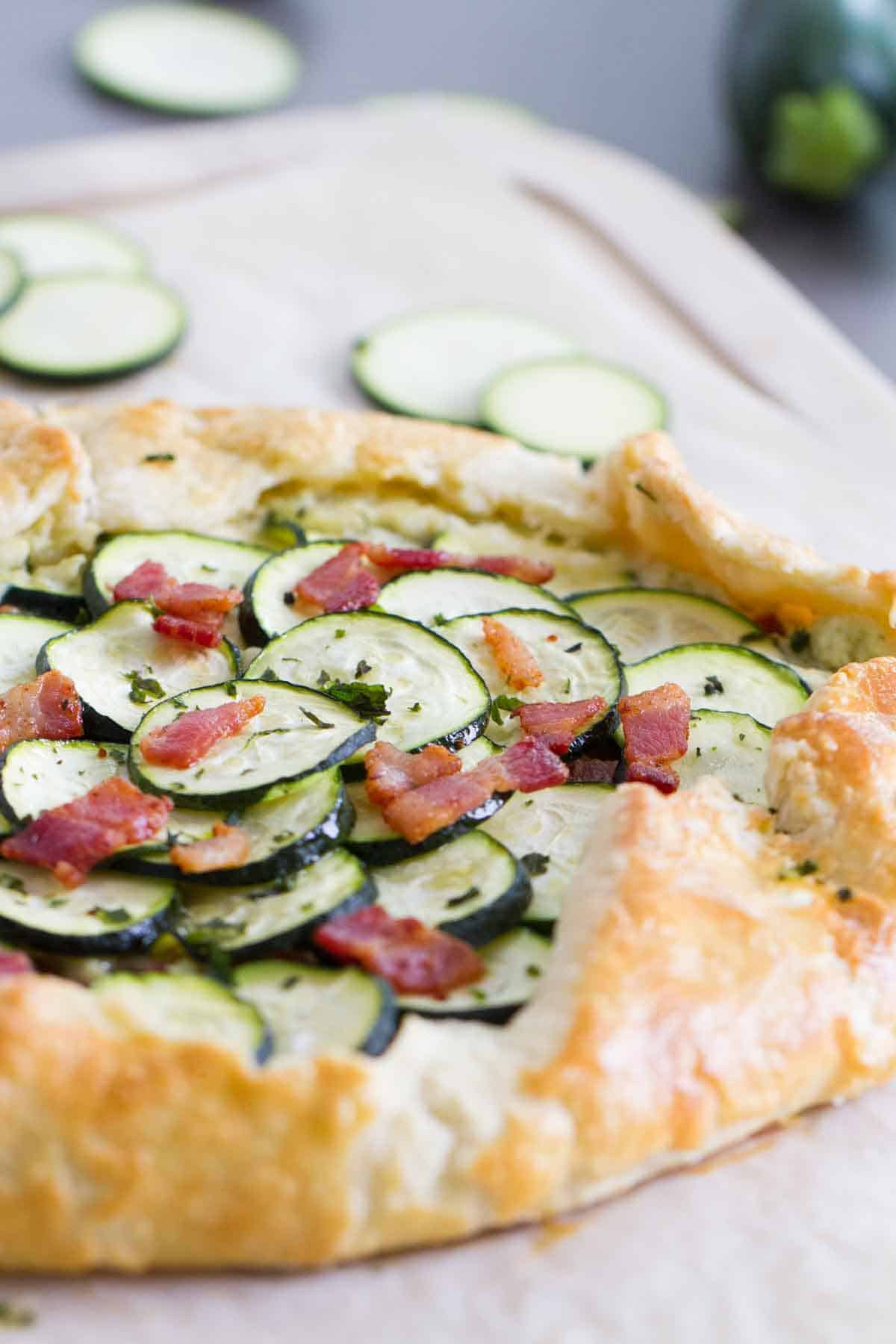 Full zucchini tart with ricotta and bacon on a cutting board