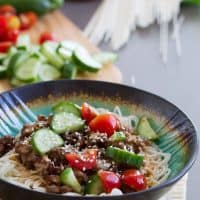 Spicy Pork Noodle Bowl with spicy pork served over Chinese noodles and topped with fresh vegetables.