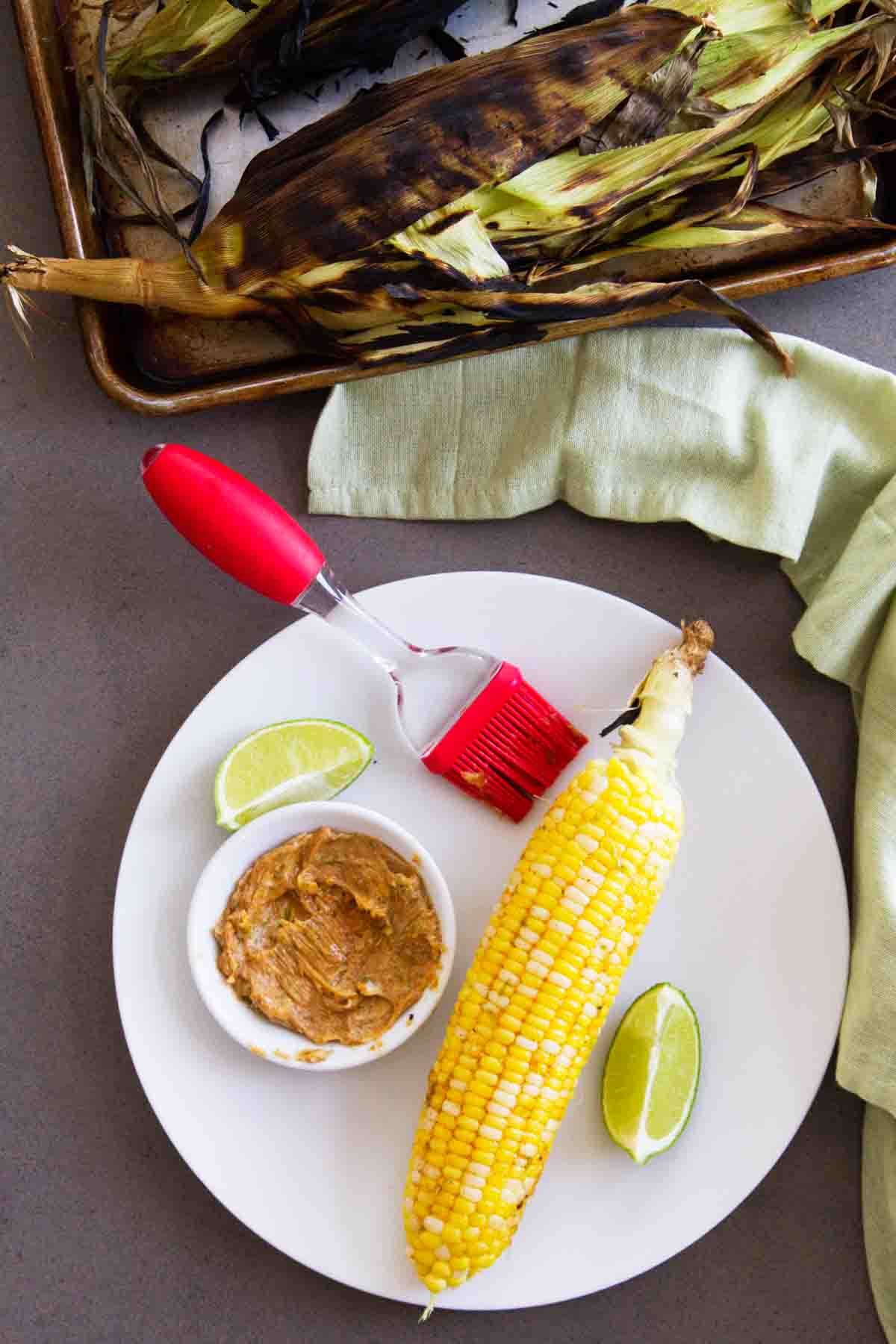 grilled corn on a plate with dish of smoky butter