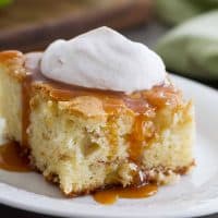 slice of apple cinnamon cake with caramel and whipped cream on a plate