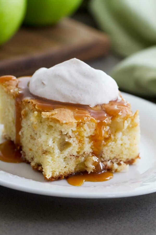 slice of apple cinnamon cake with caramel and whipped cream on a plate