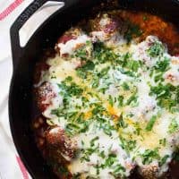 Meatball parmesan skillet topped with cheese and parmesan.