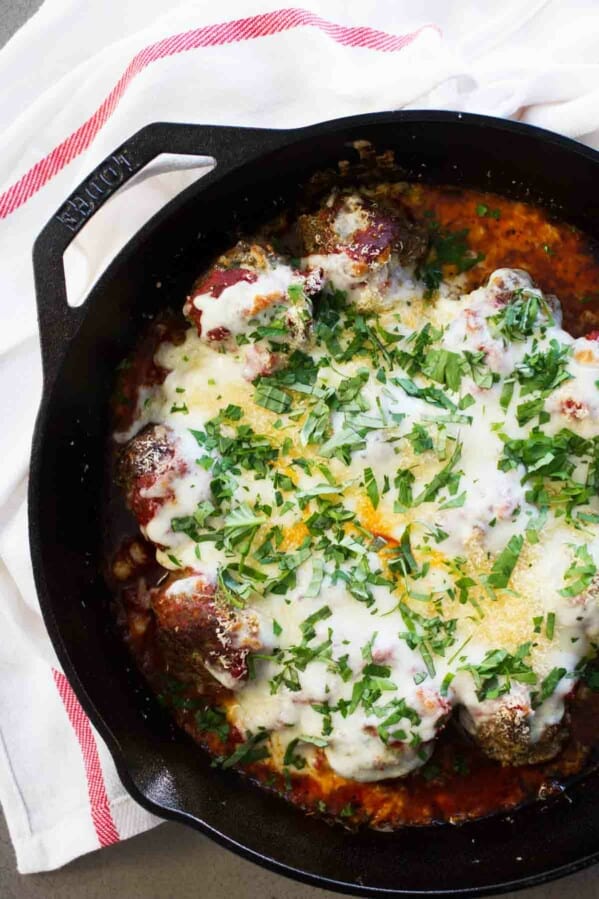 Meatball parmesan skillet topped with cheese and parmesan.