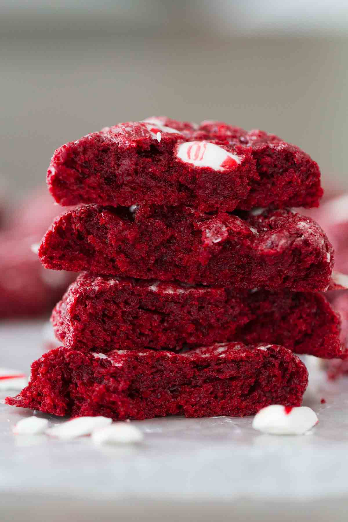 Red Velvet Peppermint Gooey Butter Cookies stacked on top of each other and broken in half.