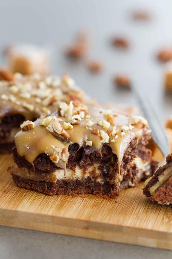 Forget the fancy bakery - these Turtle Cheesecake Cookie Bars are an impressive dessert you can make at home! A chocolate cookie base, a caramel cheesecake center, and lots of chocolate, caramel and pecans to top them off!