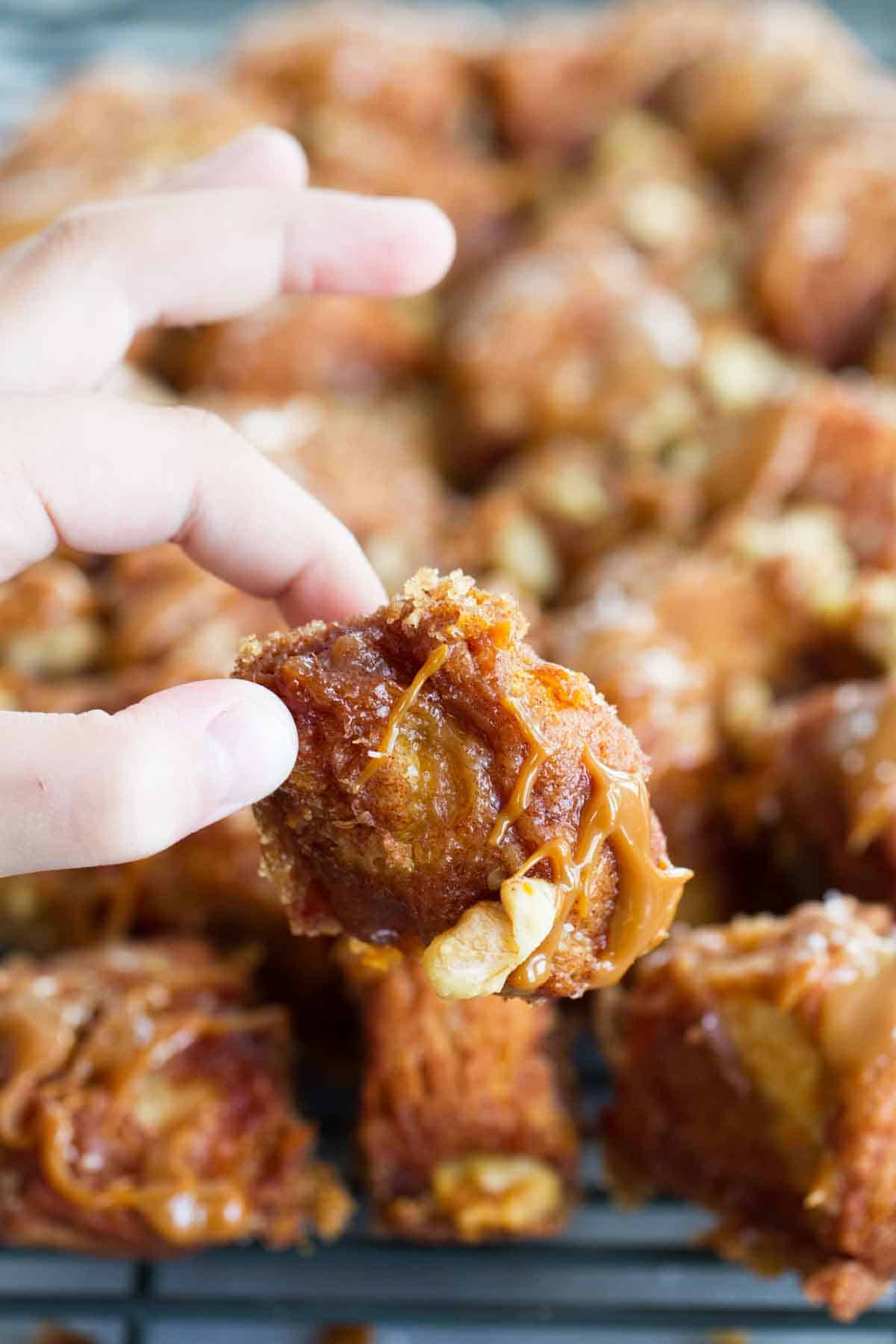 hand holding a piece of salted caramel slow cooker monkey bread