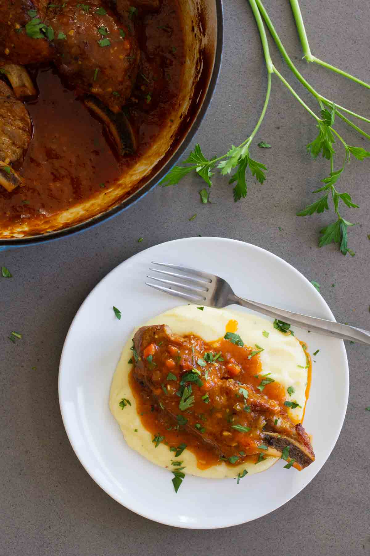 Country Style Ribs with polenta on a plate with a fork.