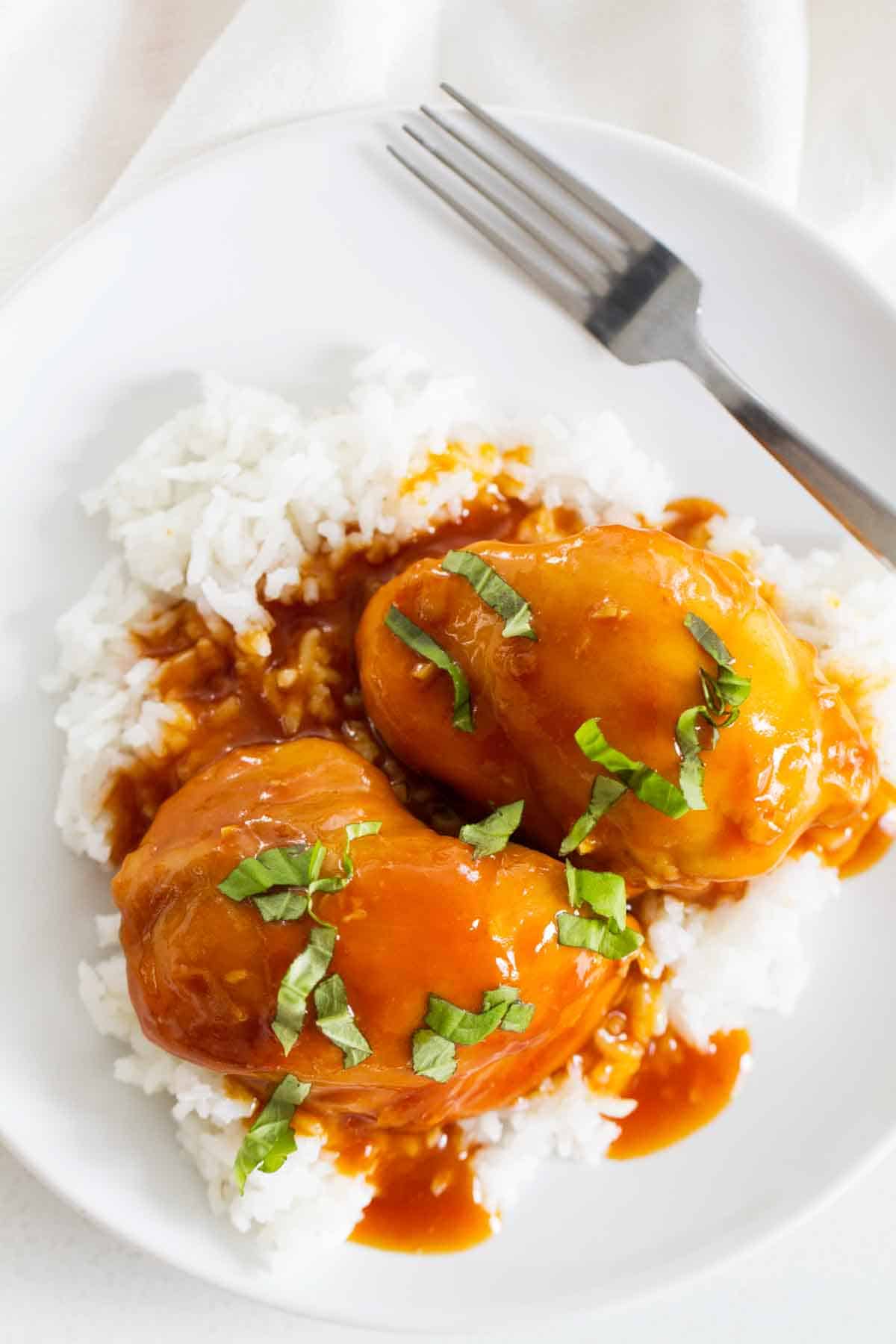 Pressure Cooker Honey Garlic Chicken over rice topped with fresh basil.