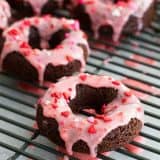 Baked Chocolate Donuts topped with cherry glaze and sprinkles.