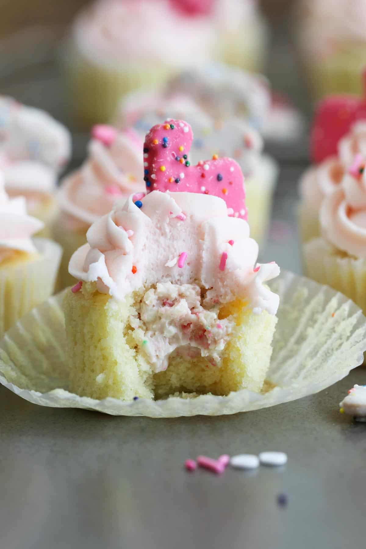 Circus Animal Cookie Cupcakes with a bite taken from it to show filling.