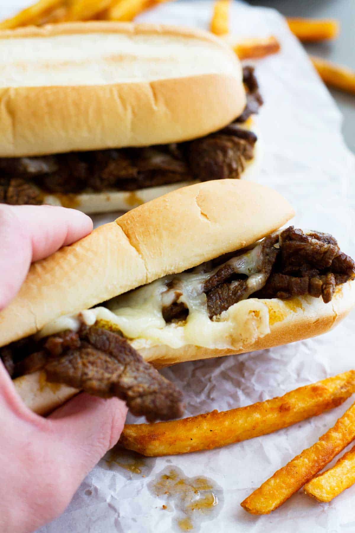 hand holding a Spicy Cajun Cheesesteak Sandwich