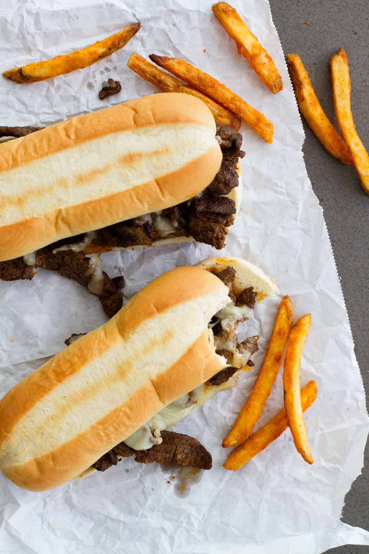 Spicy Cajun Cheesesteak Sandwiches with a bite taken from one