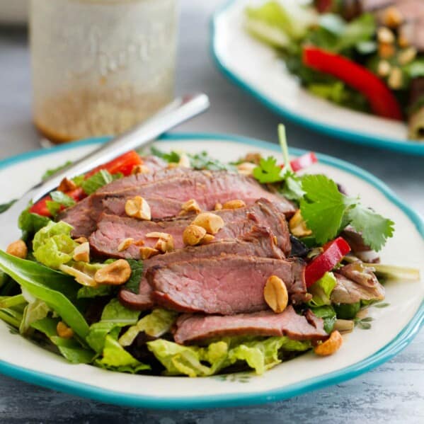 Plate with Thai Beef Salad topped with peanuts.