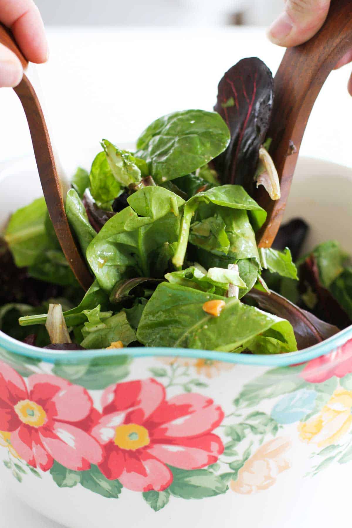 Tossing a Thai Beef Salad with wooden salad tongs.