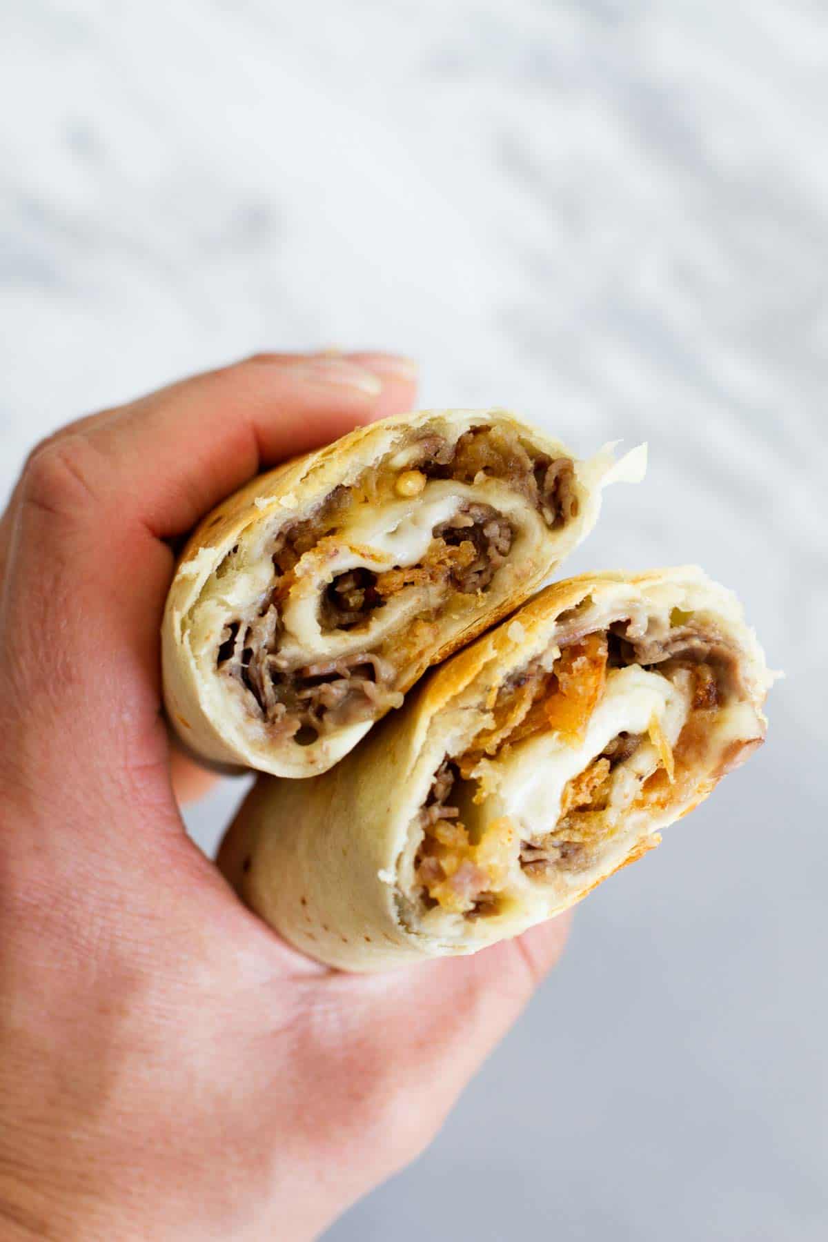 hand holidng French Dip Tortilla Roll Ups