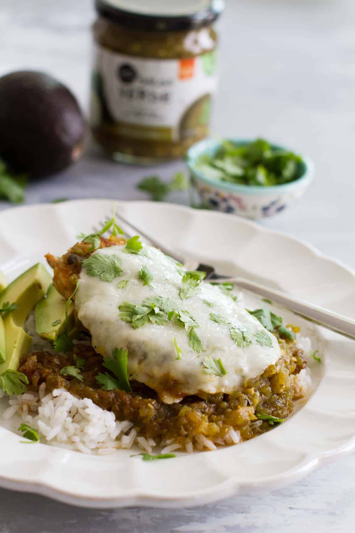 Plate with Salsa Verde Chicken with cheese and cilantro.