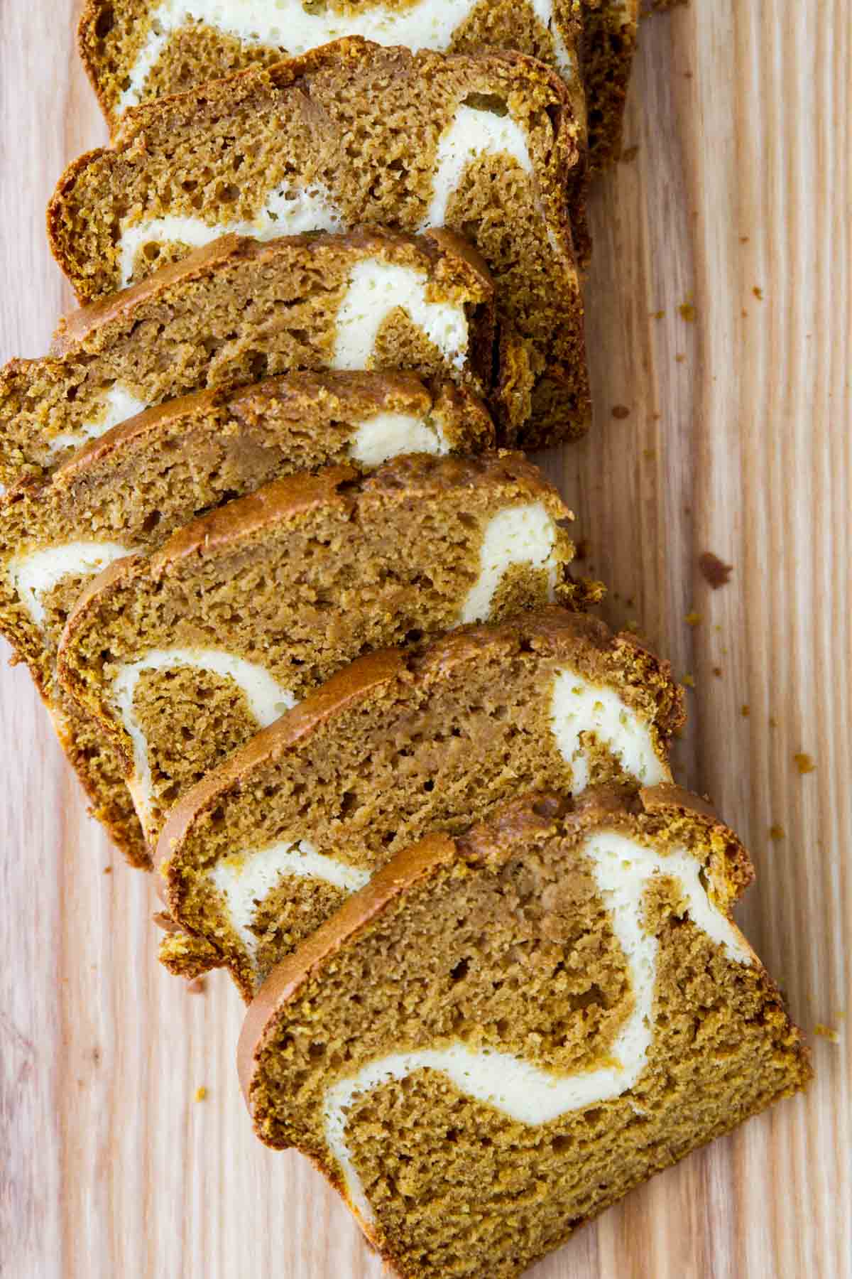 Cream Cheese Pumpkin Bread sliced on a cutting board.